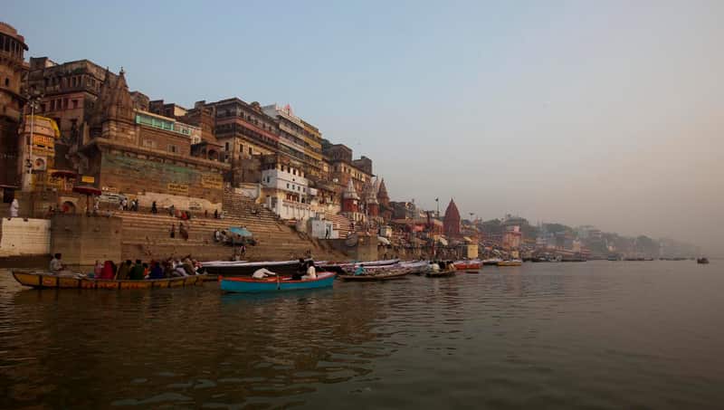 A priest performing a small ritual on the lower platform of the ghat