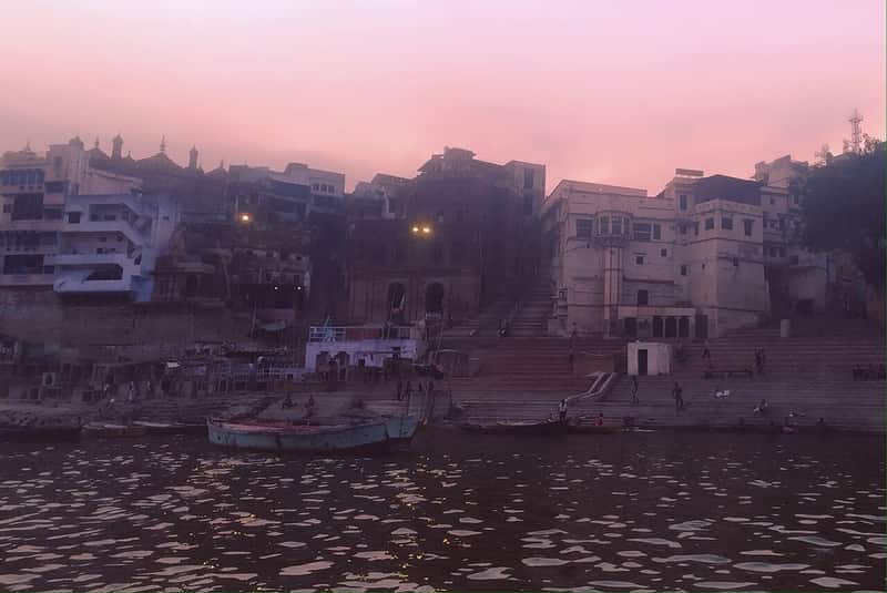 Pilgrims seated quietly on the steps of Brahma Ghat