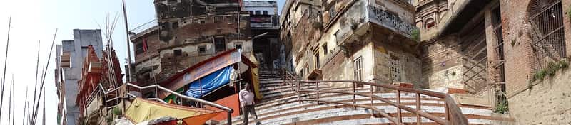Boatmen resting on their wooden boats beside the steps at Durga Ghat