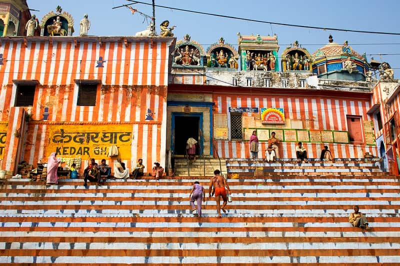 A saffron-clad sadhu seated on the steps at Kedar Ghat