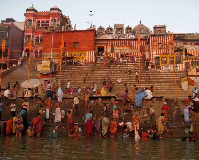 A weathered shrine and old well above the steps of Kedar Ghat