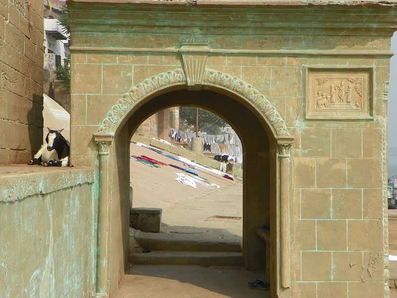 A priest and a devotee talking on the steps of Lal Ghat