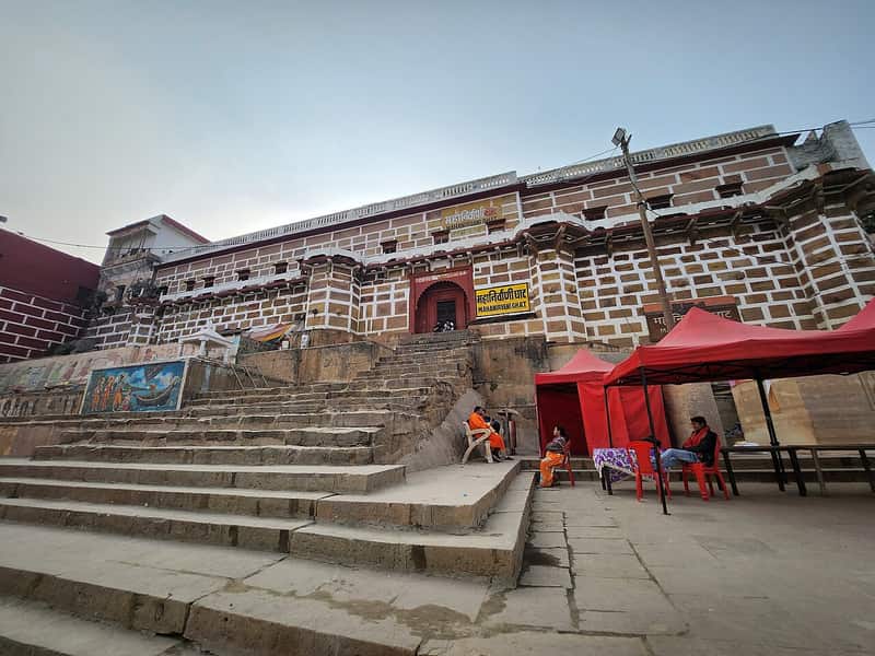 Naga ascetics with ash-smeared bodies sitting on the ghat steps