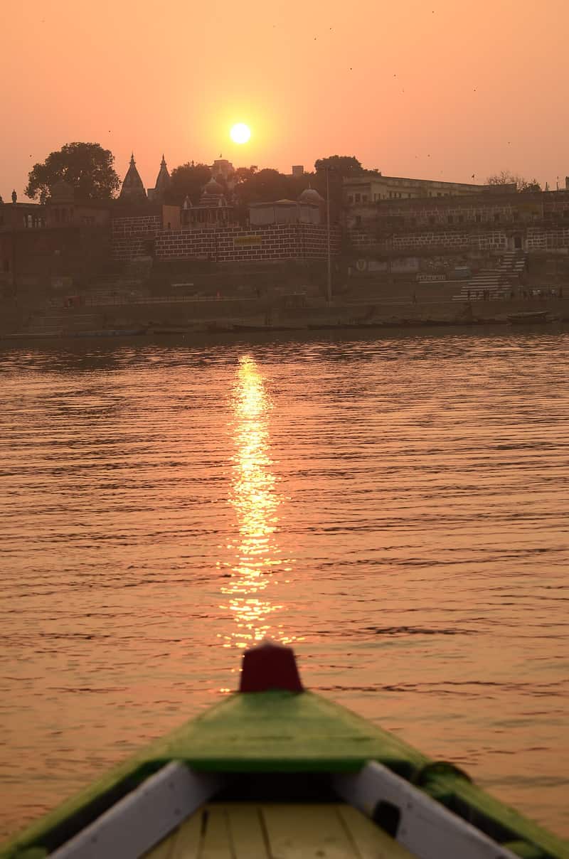 A festival procession of sadhus descending the ghat steps with banners and drums