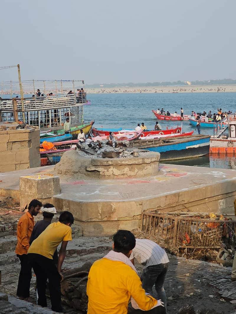 The moody atmosphere of the ghat with smoke rising