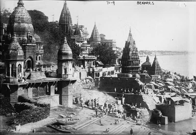 A devotee offering a lamp on the ghat steps