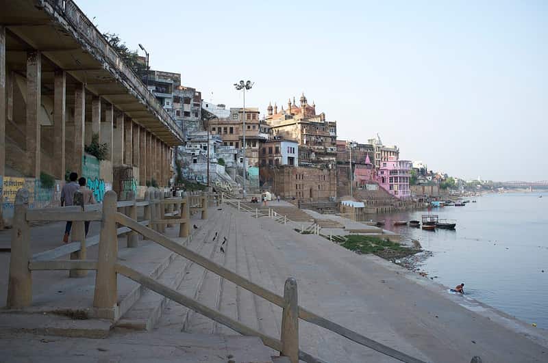 A narrow lane rising from the ghat between old houses with hanging balconies