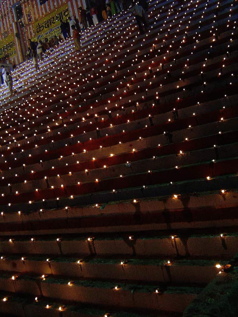 Rows of oil lamps glowing on the ghat steps during Dev Deepawali