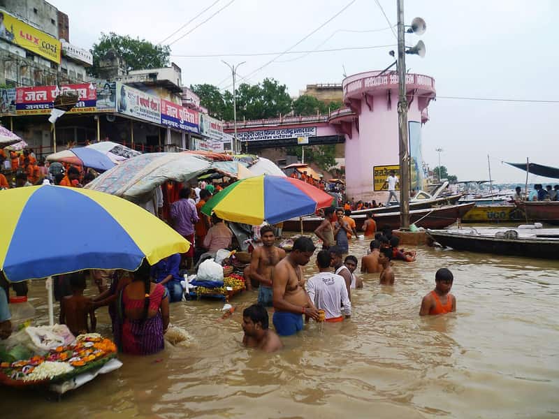 Devotees offering prayers respectfully at the water's edge