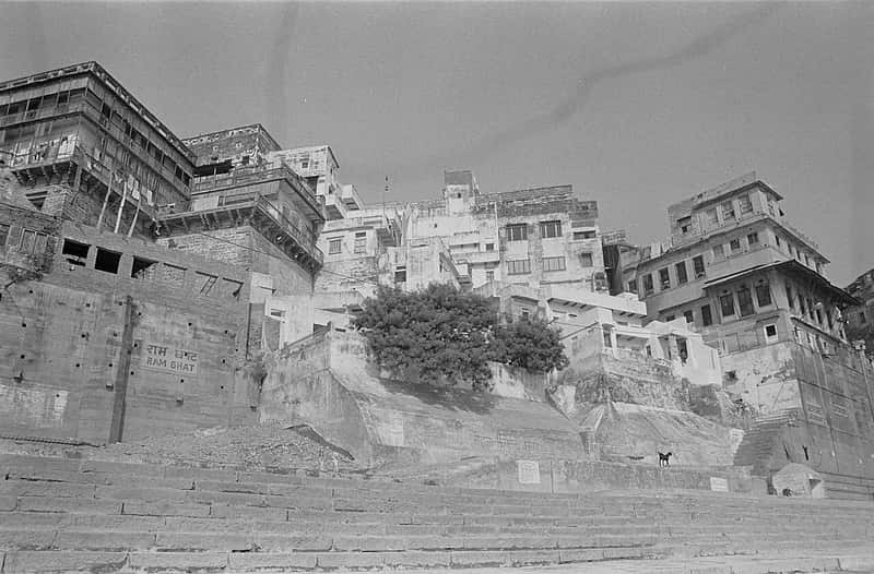 A narrow lane rising from the ghat between old houses with hanging balconies