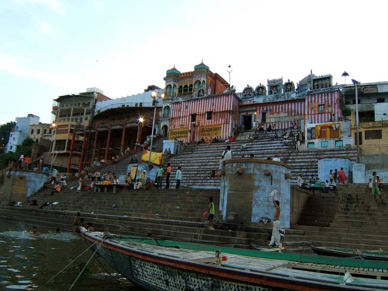 Wooden boats moored along the ghat with boatmen at work
